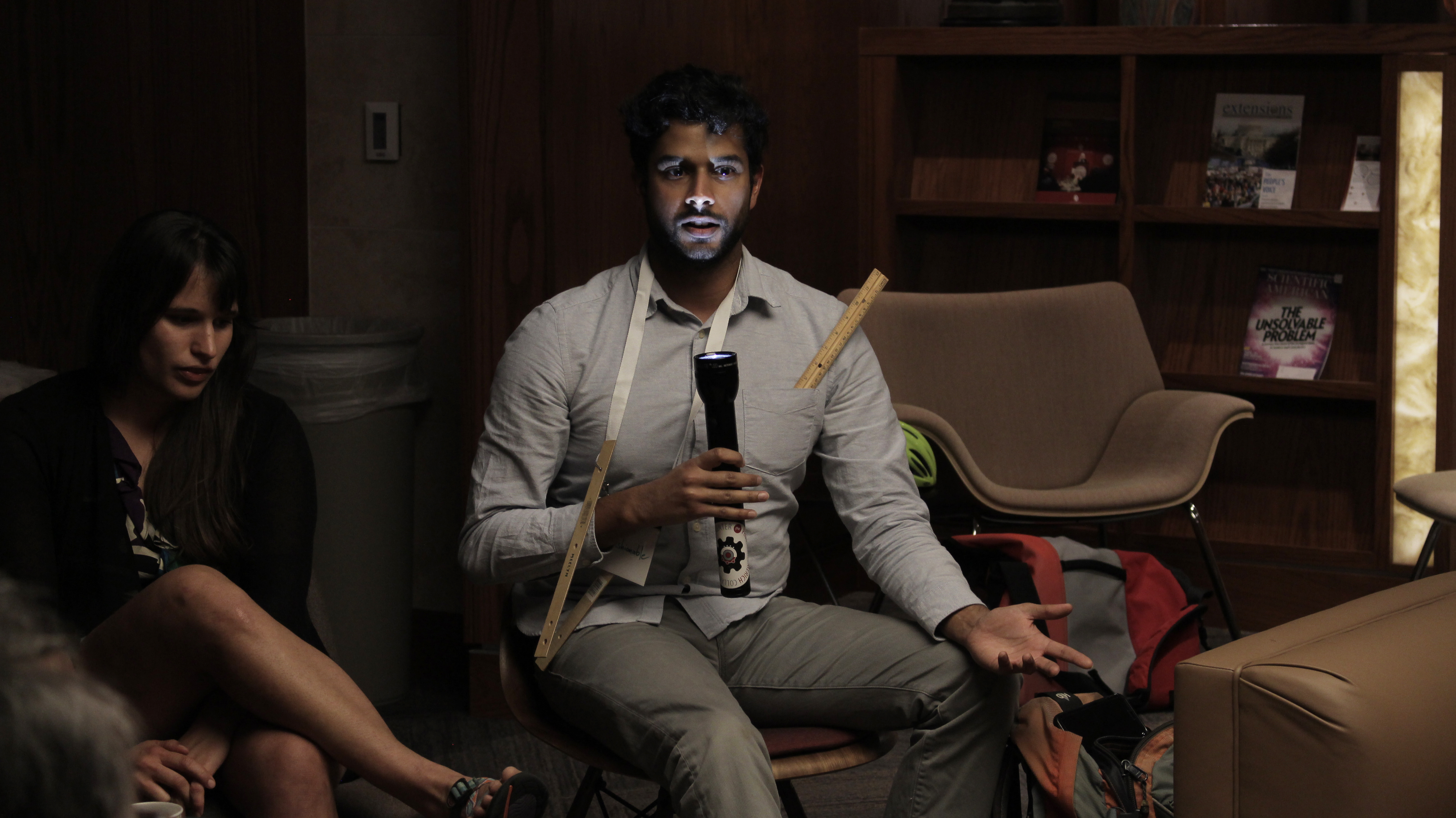 An event participant is illuminating his face with a flashlight